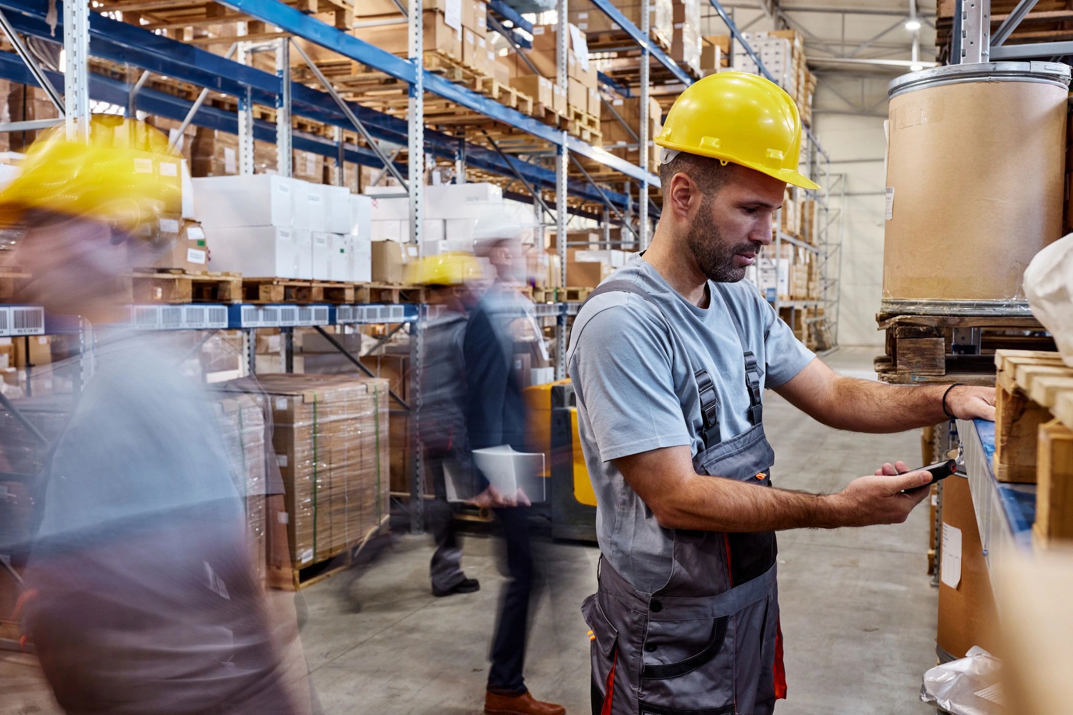 Manual worker scanning the bar code of a package in storage room.